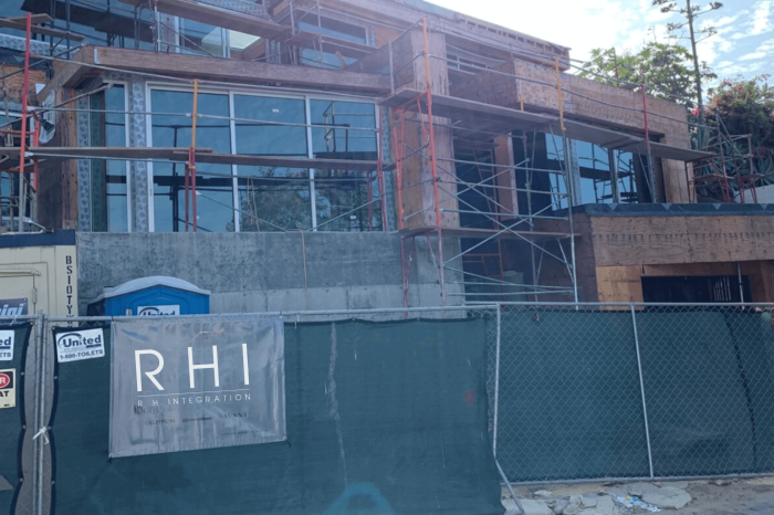 Building under construction with scaffolding and fencing.