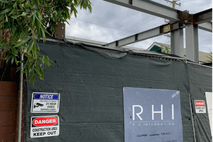Construction site with warning signs and tarp.